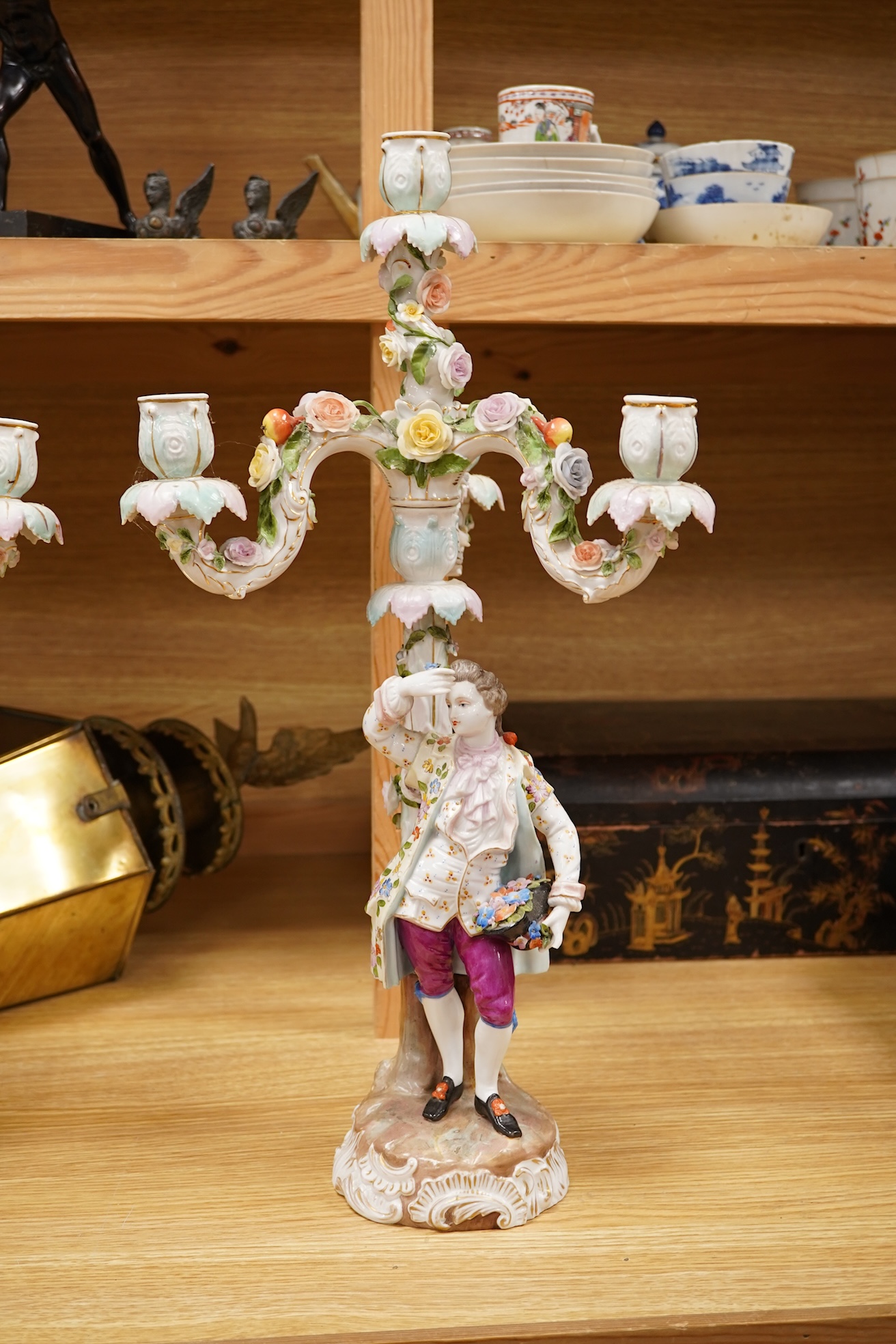 A pair of Volkstedt porcelain figural three branch candelabra with floral encrusted decoration, 51cm high